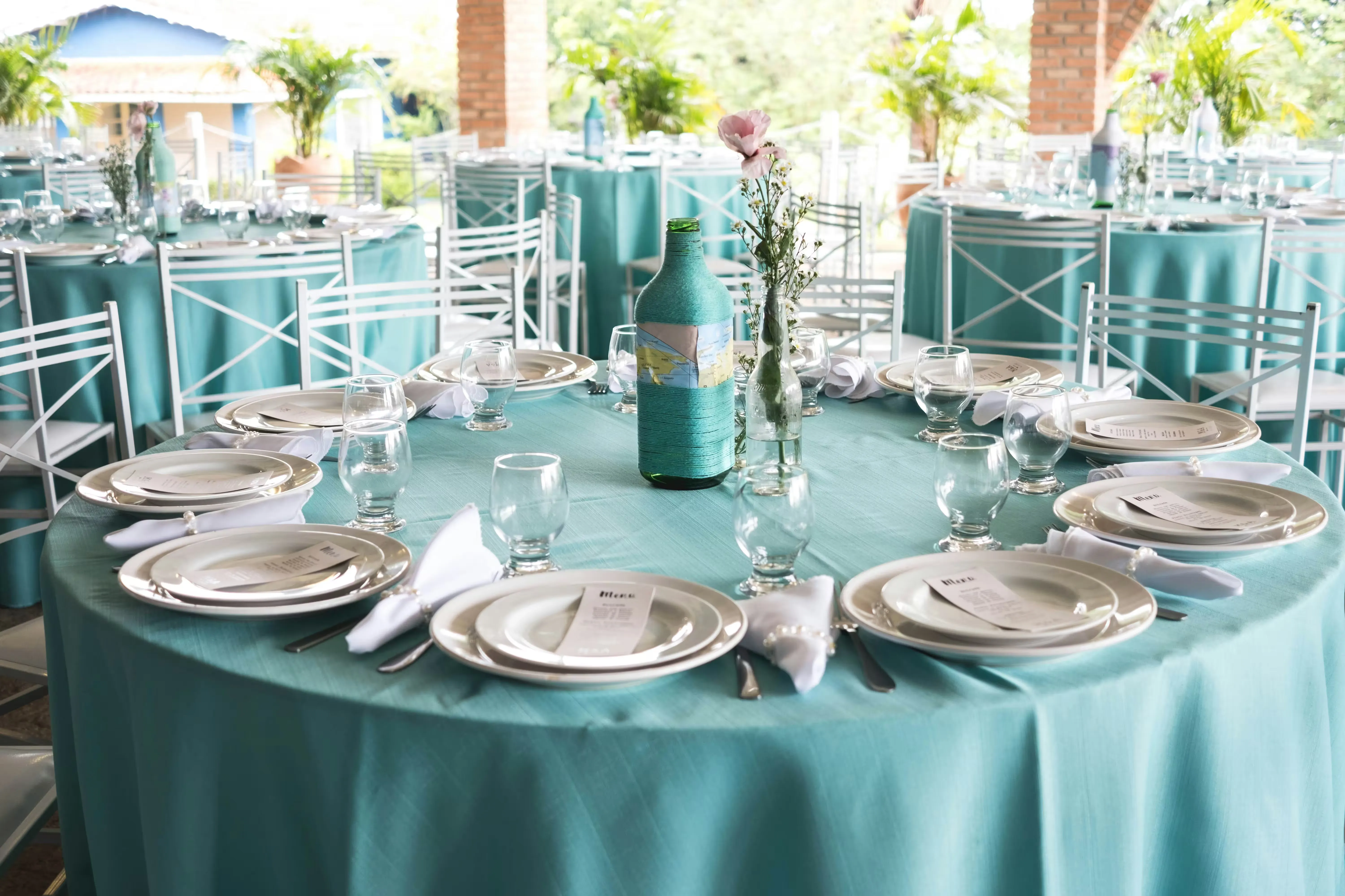 A teal-styled outdoor table setting on a patio